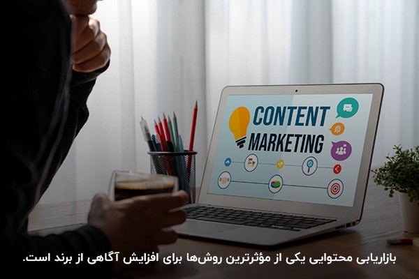 فردی در حال تولید محتوا با لپتاپ برای جذب مخاطبان و افزایش آگاهی از برند