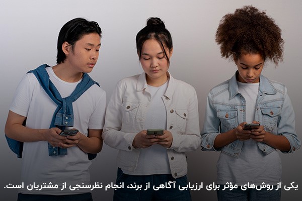 افرادی در حال انجام نظرسنجی با گوشی موبایل برای سنجش میزان آگاهی از برند