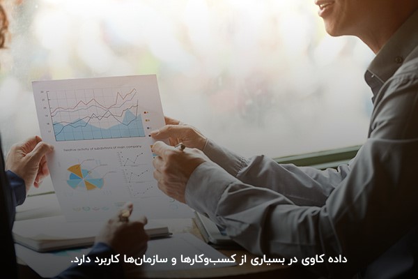 دو کارشناس در حال تحلیل اطلاعات آماری داده کاوی برای تصمیمگیری در کسبوکار