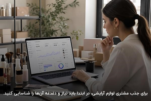 زنی جوان در حال کار با لپتاپ و انواع لوازم آرایشی روی میز
